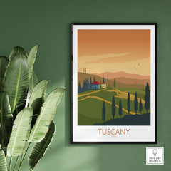Tuscany poster print featuring a vintage landscape design of Italy, framed against a green wall with tropical plants.
