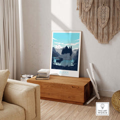 Alaska print travel poster displayed in a cozy living room setting, featuring mountains and wildlife.
