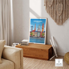 Copenhagen Print displayed in a minimalist living room, showcasing vintage-inspired travel art on a wooden table.