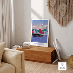 Vintage-inspired Hong Kong travel poster framed in a stylish living room setting, showcasing a traditional boat and skyline.