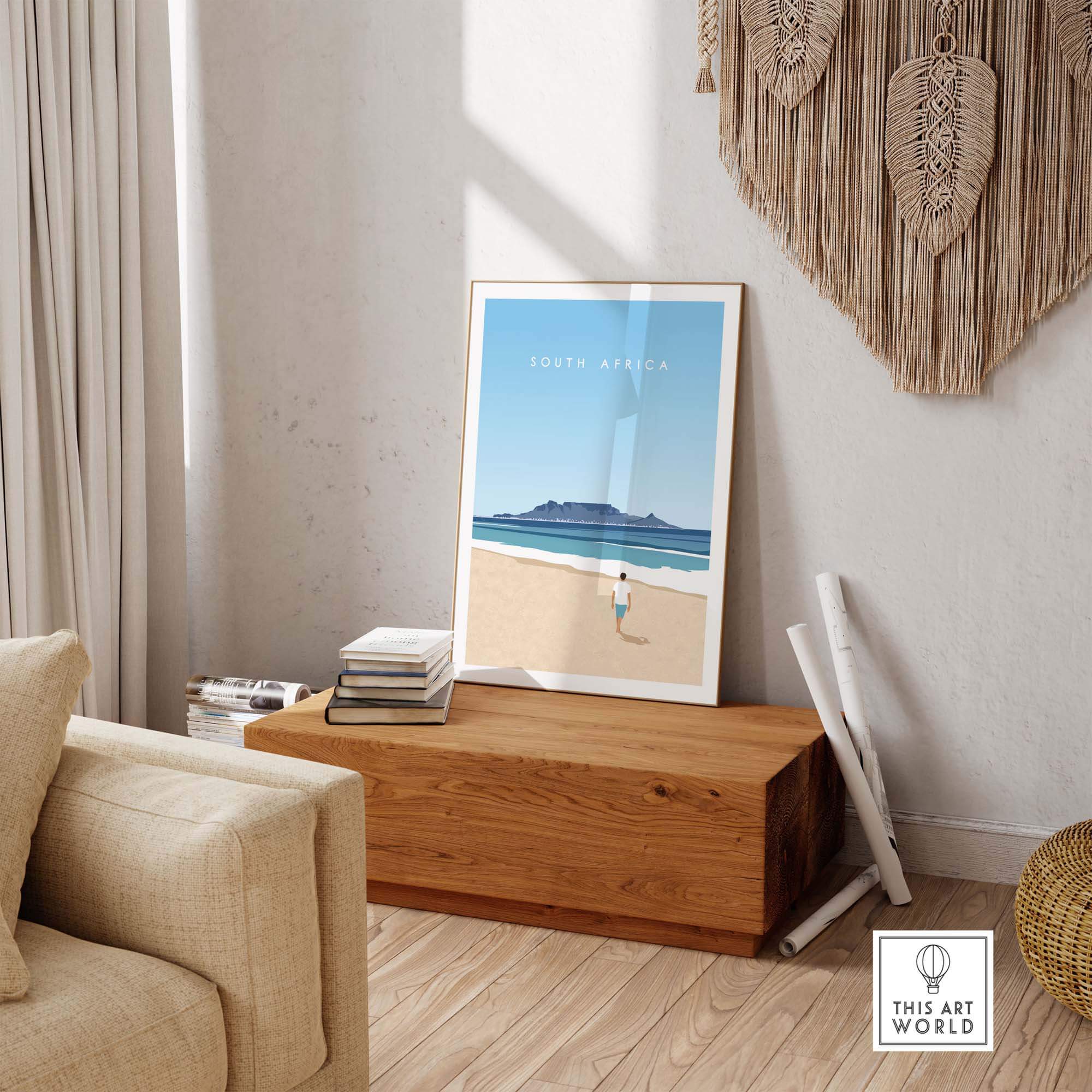 South Africa travel poster print displayed in a minimalist living room setting, showcasing coastal scenery and vintage design.