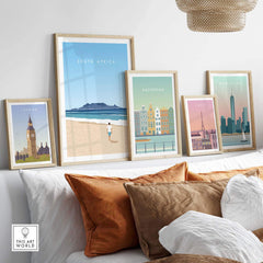 Framed South Africa travel poster print alongside other city art prints in a stylish home interior.