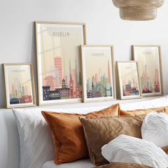 Framed city skyline wall art featuring Dublin, London, Sydney, and Hong Kong in warm pastel tones.