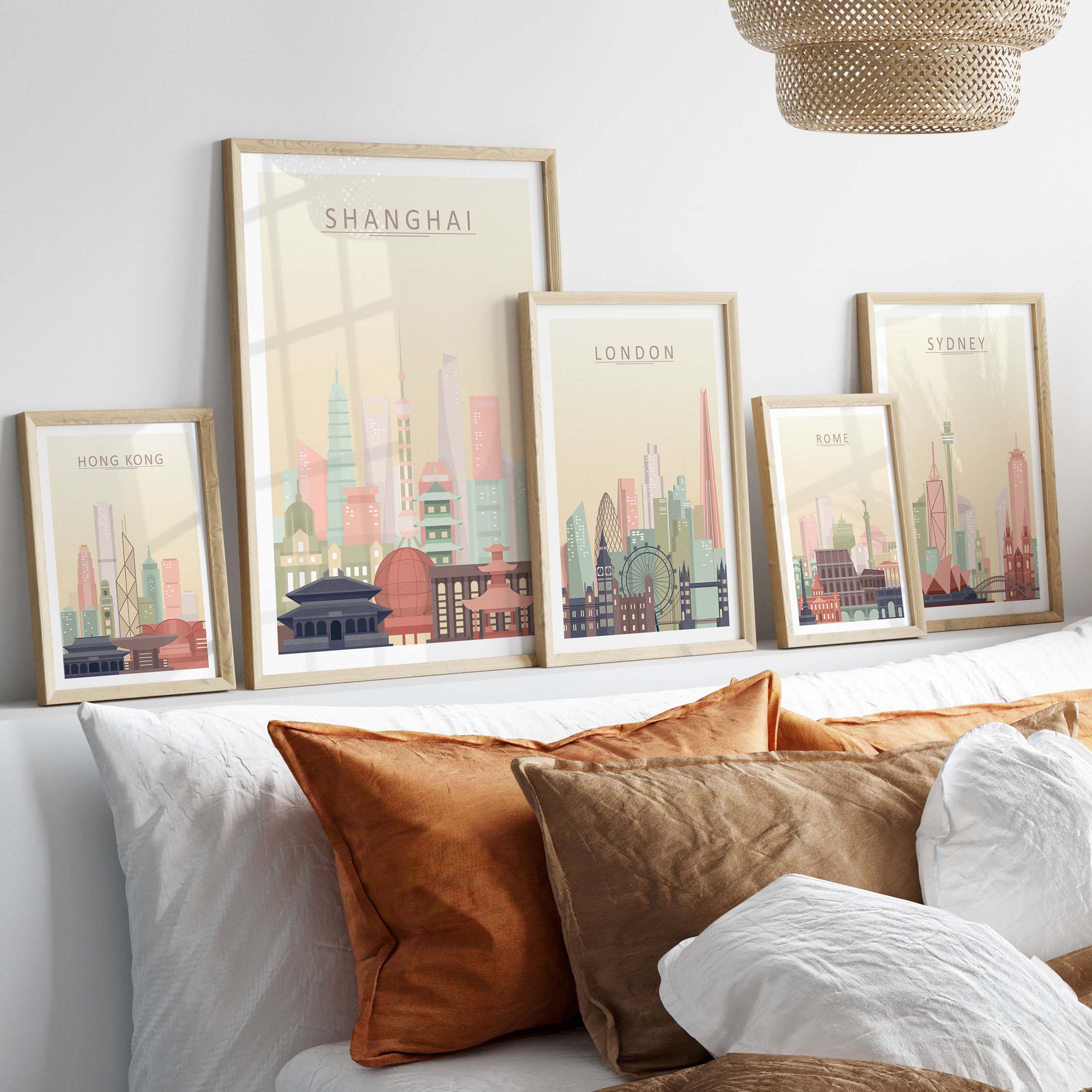 Gallery of city skyline prints featuring Shanghai, London, Sydney, and Hong Kong in pastel tones, styled on a cozy bed.