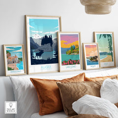 Stylish collection of travel posters featuring Alaska, Lake Como, Amalfi Coast, San Juan, and Maui in a cozy home setting.