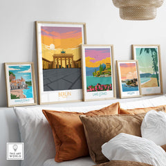 Stylish framed Berlin print and vintage travel posters on a cozy sofa, showcasing travel destinations like Amalfi Coast and Lake Como.