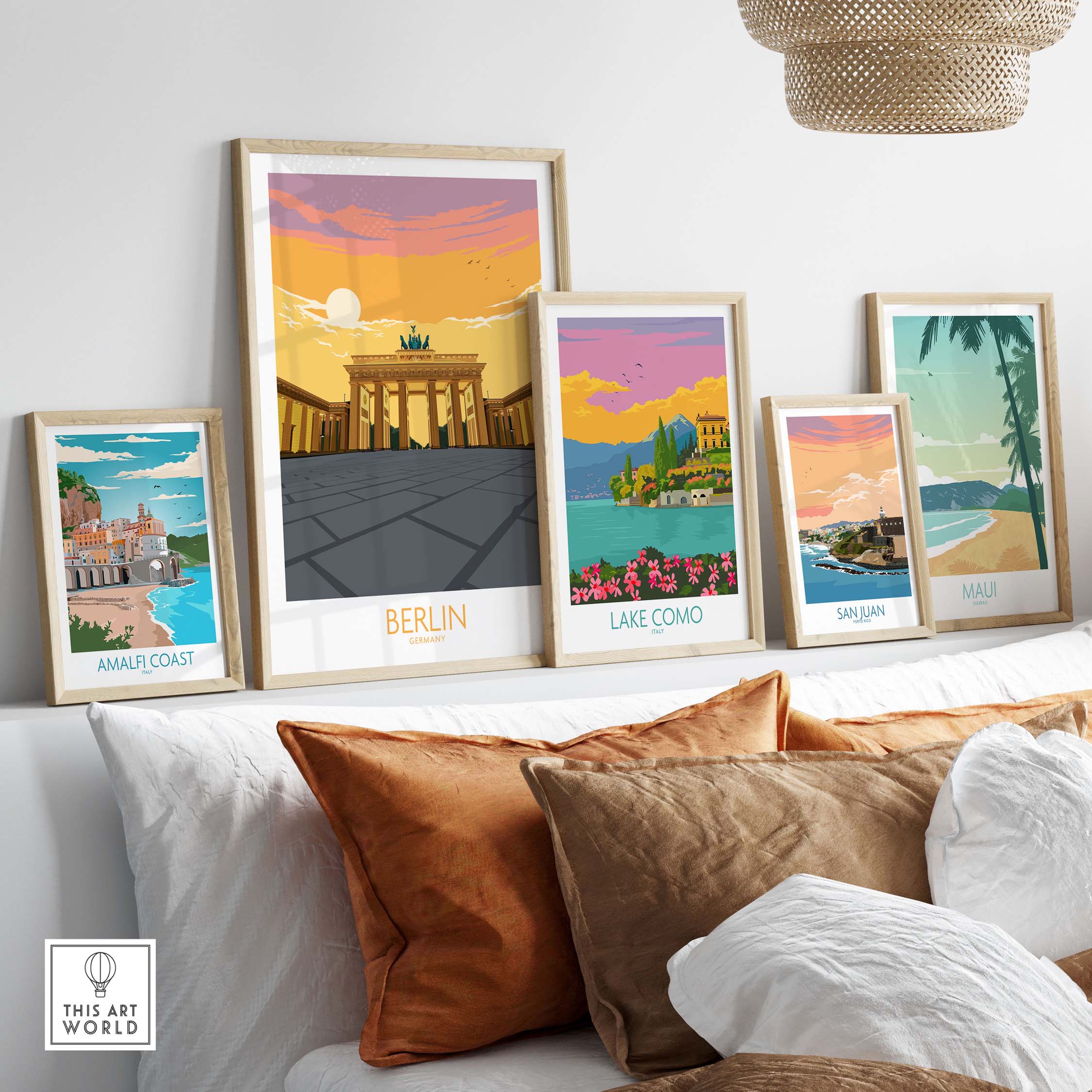 Stylish framed Berlin print and vintage travel posters on a cozy sofa, showcasing travel destinations like Amalfi Coast and Lake Como.
