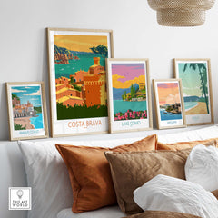 Framed Costa Brava poster and other vintage travel art prints displayed on a sofa, showcasing stylish wall decor.