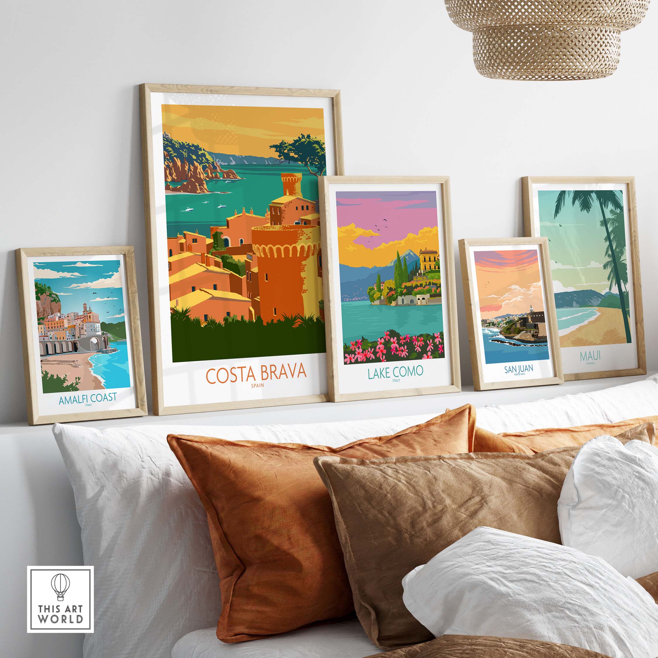 Framed Costa Brava poster and other vintage travel art prints displayed on a sofa, showcasing stylish wall decor.