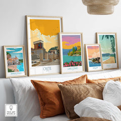 Framed travel posters including Crete, Amalfi Coast, Lake Como, San Juan, and Maui displayed in a modern living space.