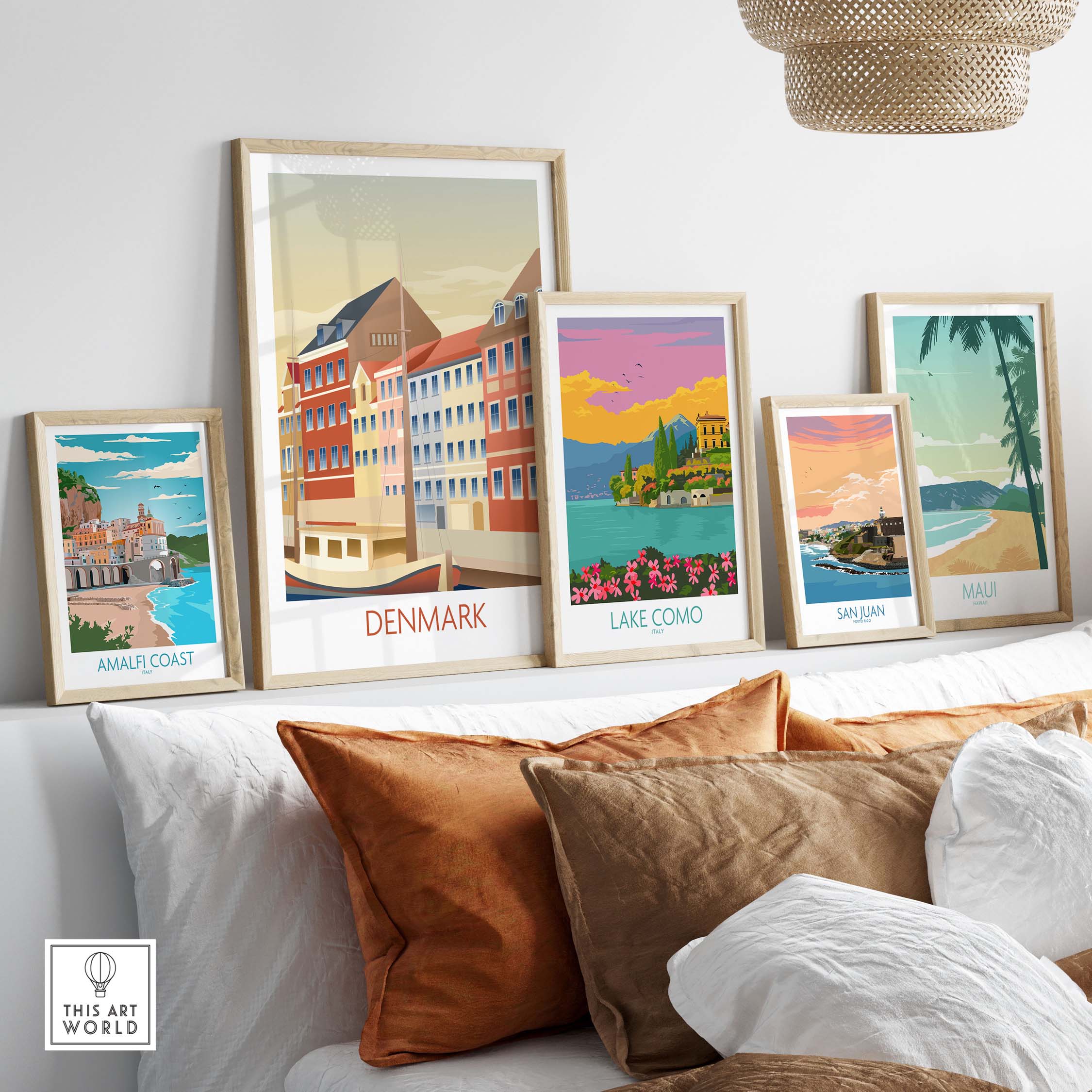Colorful Denmark poster art print displayed with travel-themed artworks on a sofa in a stylish living room.