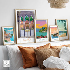 Stylish travel poster prints of Granada, Lake Como, Amalfi Coast, San Juan, and Maui displayed in a modern living room.