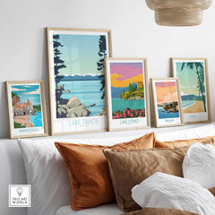Framed vintage travel art prints featuring Lake Tahoe, Amalfi Coast, Lake Como, San Juan, and Maui, displayed in a cozy home setting.