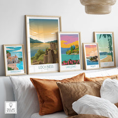 Loch Ness print among framed vintage-style travel posters on a stylish sofa, showcasing Scotland's beauty.
