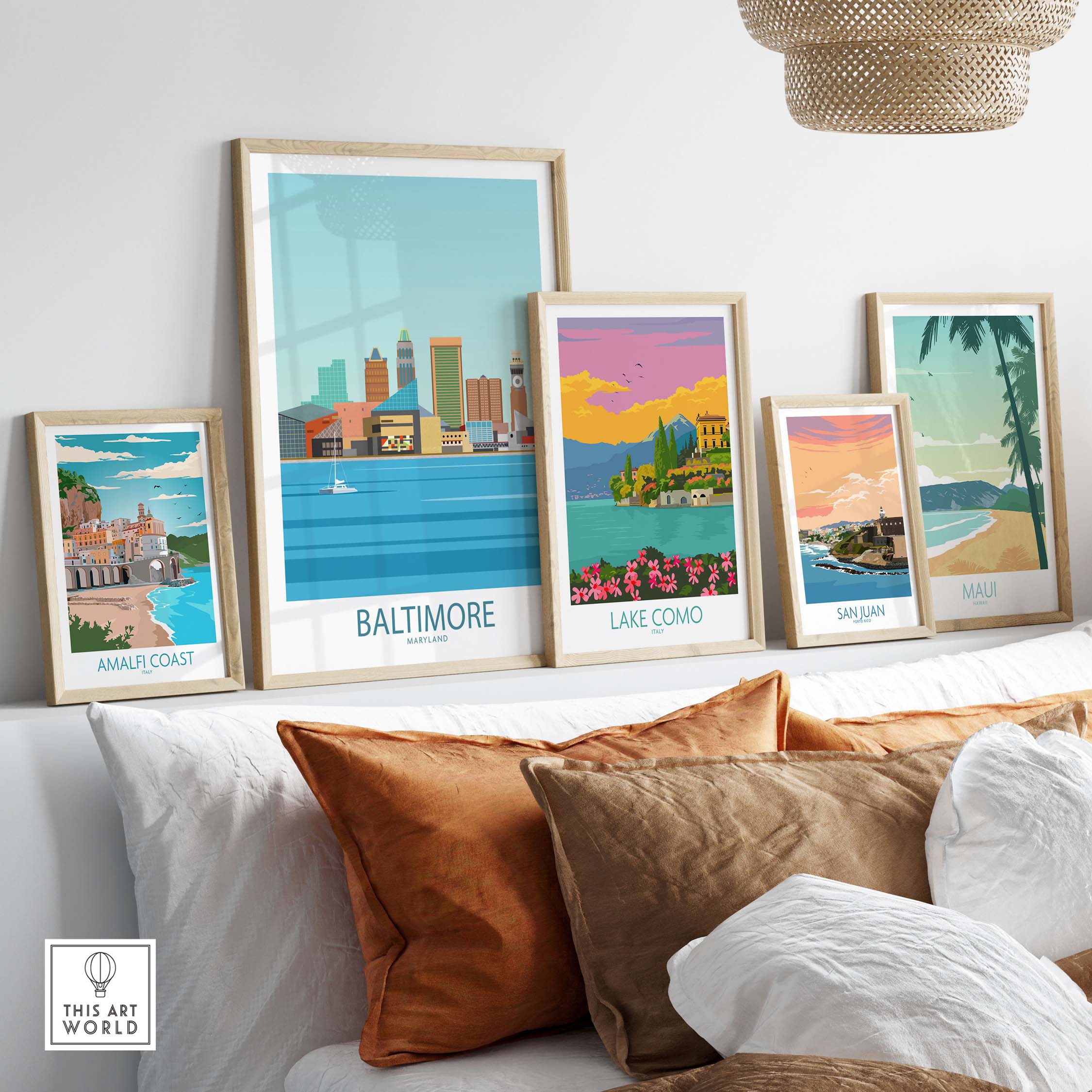 Baltimore travel poster among framed art depicting Amalfi Coast, Lake Como, San Juan, and Maui in a stylish home setting.