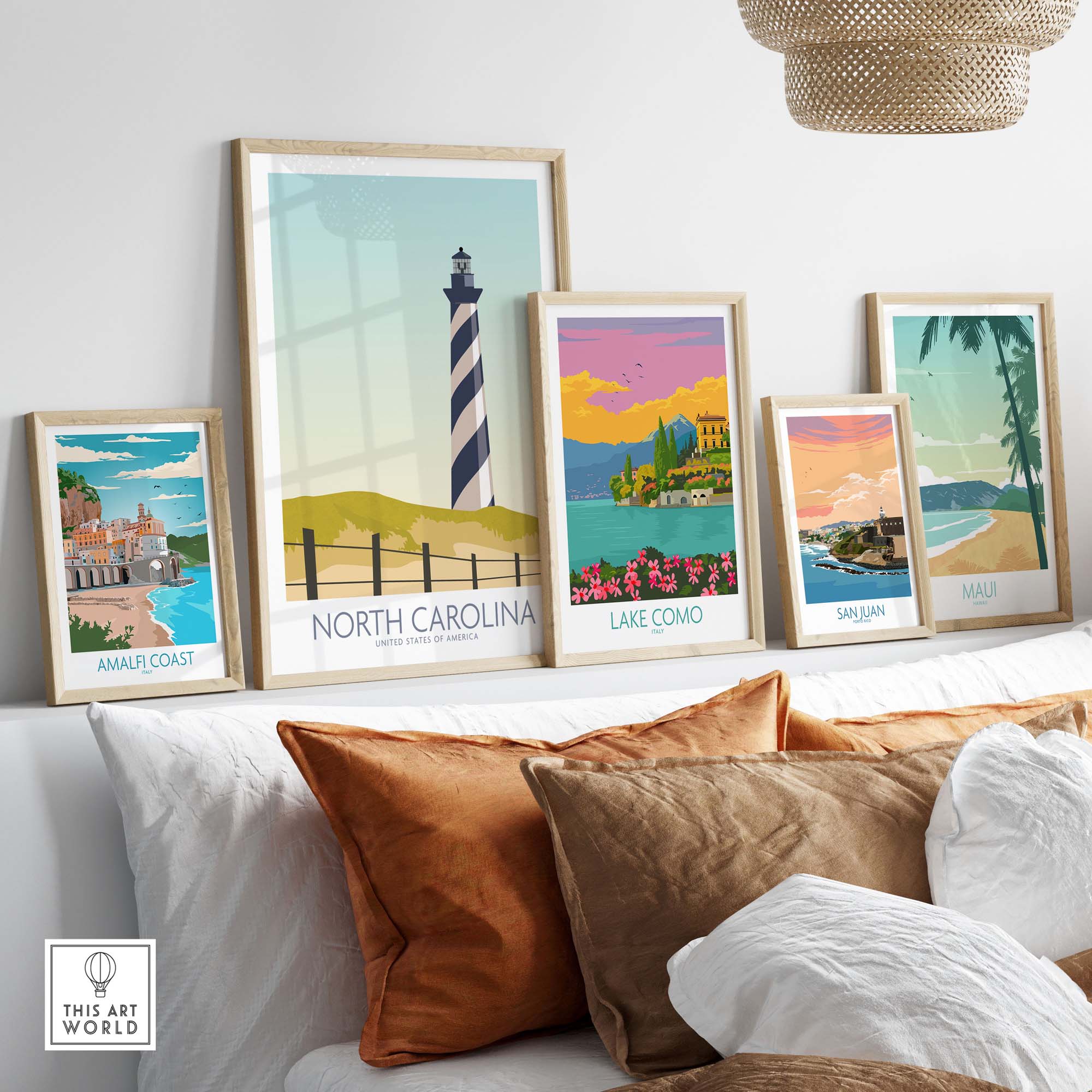 Framed North Carolina wall art print displayed among other vintage travel posters on a sofa.