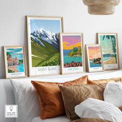Framed Mont Blanc print and vintage travel posters on a stylish sofa, showcasing wanderlust decor.
