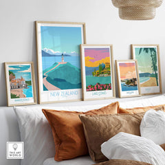 Stylish New Zealand travel poster among other vintage art prints displayed on a cozy sofa.