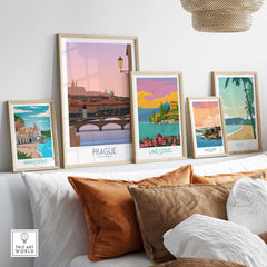 Stylish travel posters including Prague, Amalfi Coast, Lake Como, San Juan, and Maui displayed on a cozy sofa.