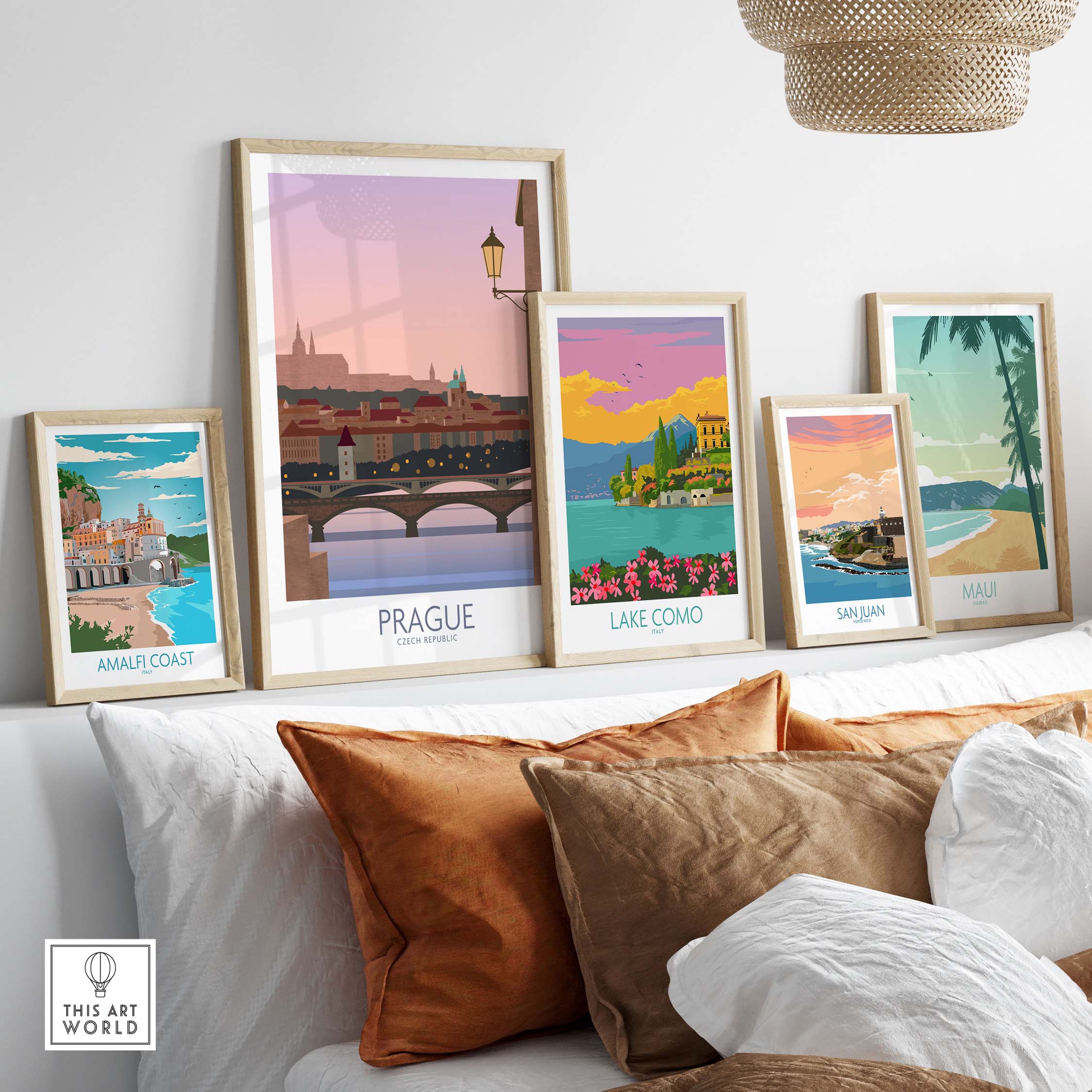 Stylish travel posters including Prague, Amalfi Coast, Lake Como, San Juan, and Maui displayed on a cozy sofa.