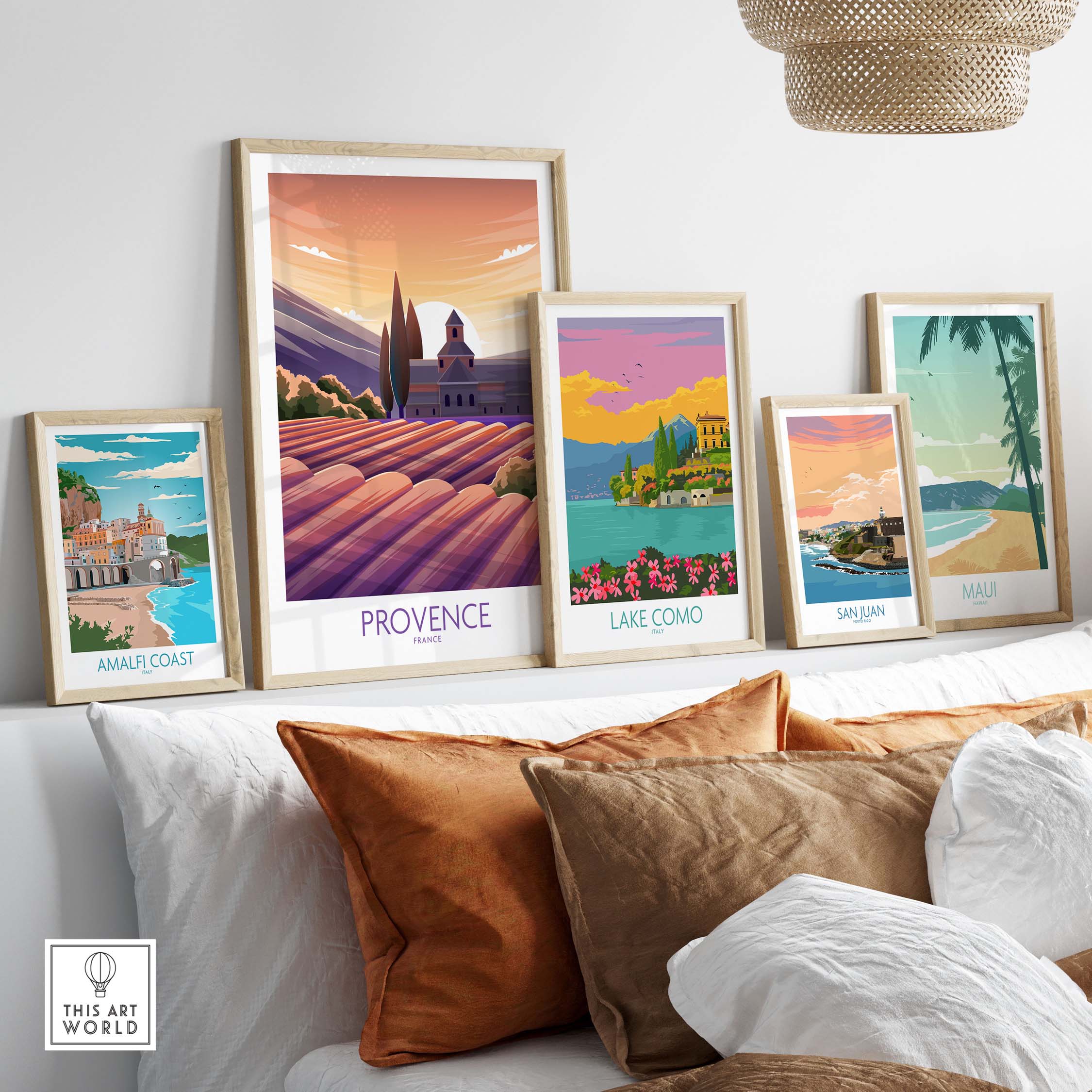 Framed travel posters featuring Provence, Lake Como, Amalfi Coast, San Juan, and Maui displayed in a stylish home setting.