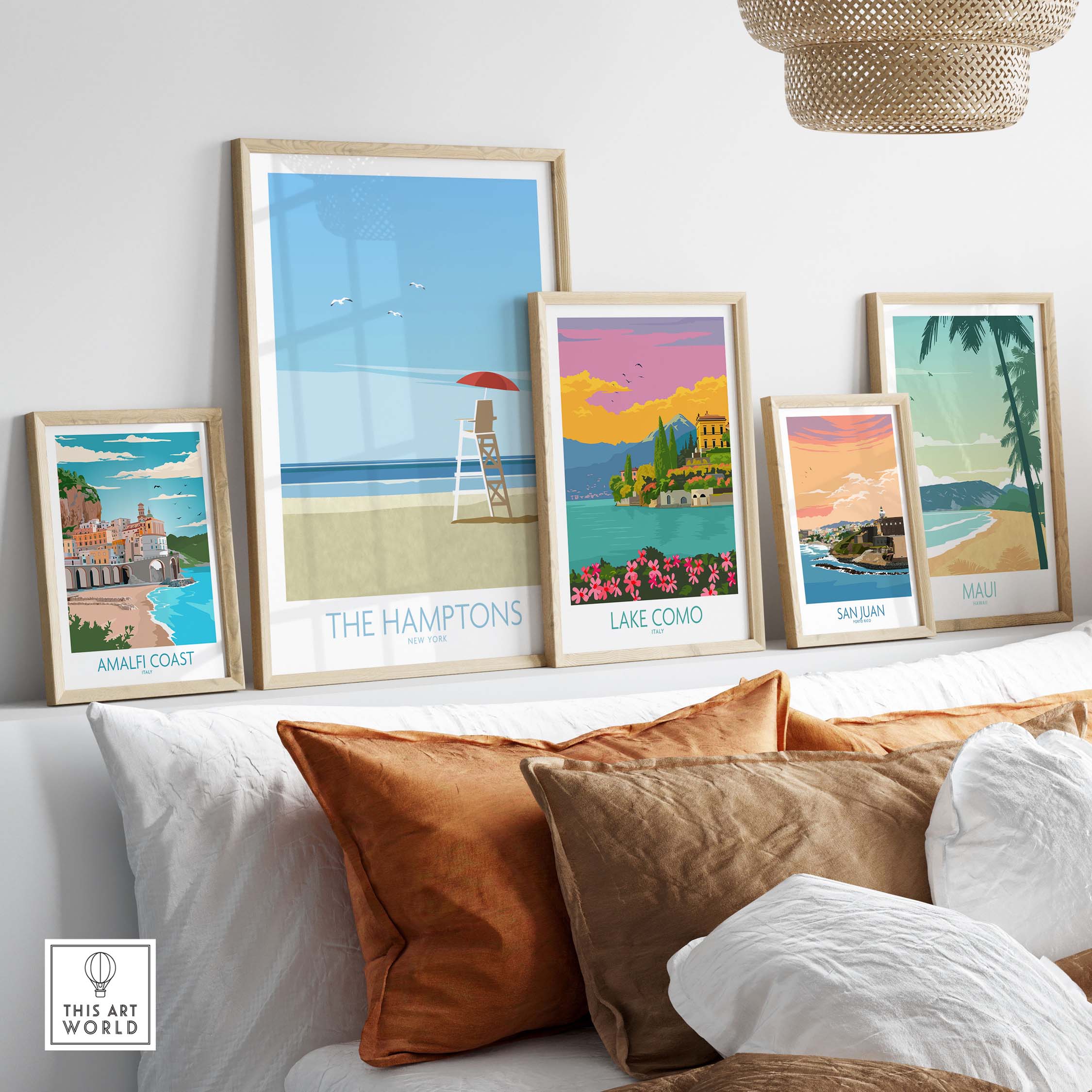 Framed travel wall art featuring The Hamptons, Lake Como, San Juan, and Maui, styled in a cozy living room setting.