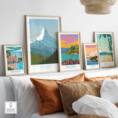 A stylish display of framed travel posters including Zermatt, Amalfi Coast, Lake Como, San Juan, and Maui.