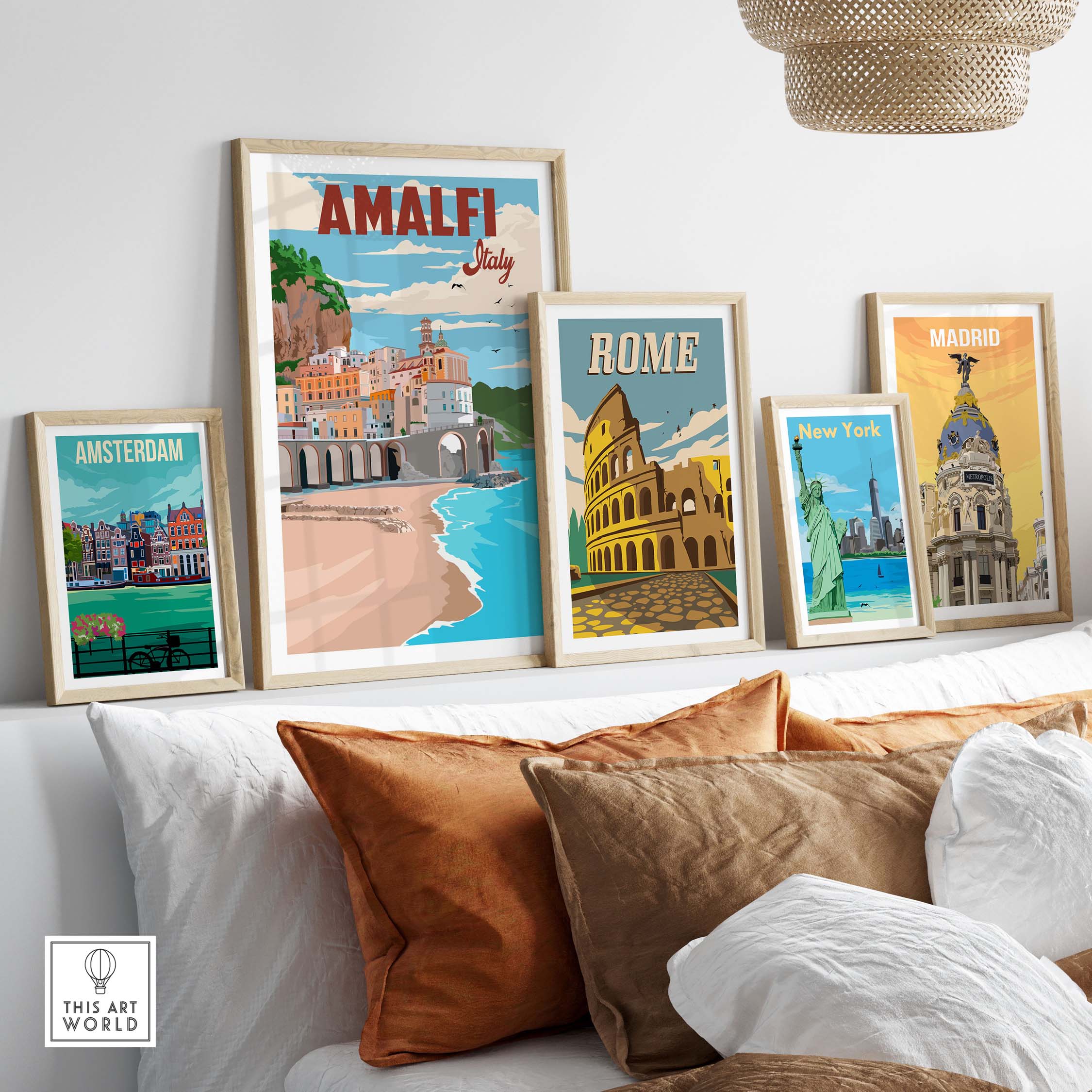 Amalfi Coast vintage poster art displayed with other city prints on a cozy wall above a sofa.