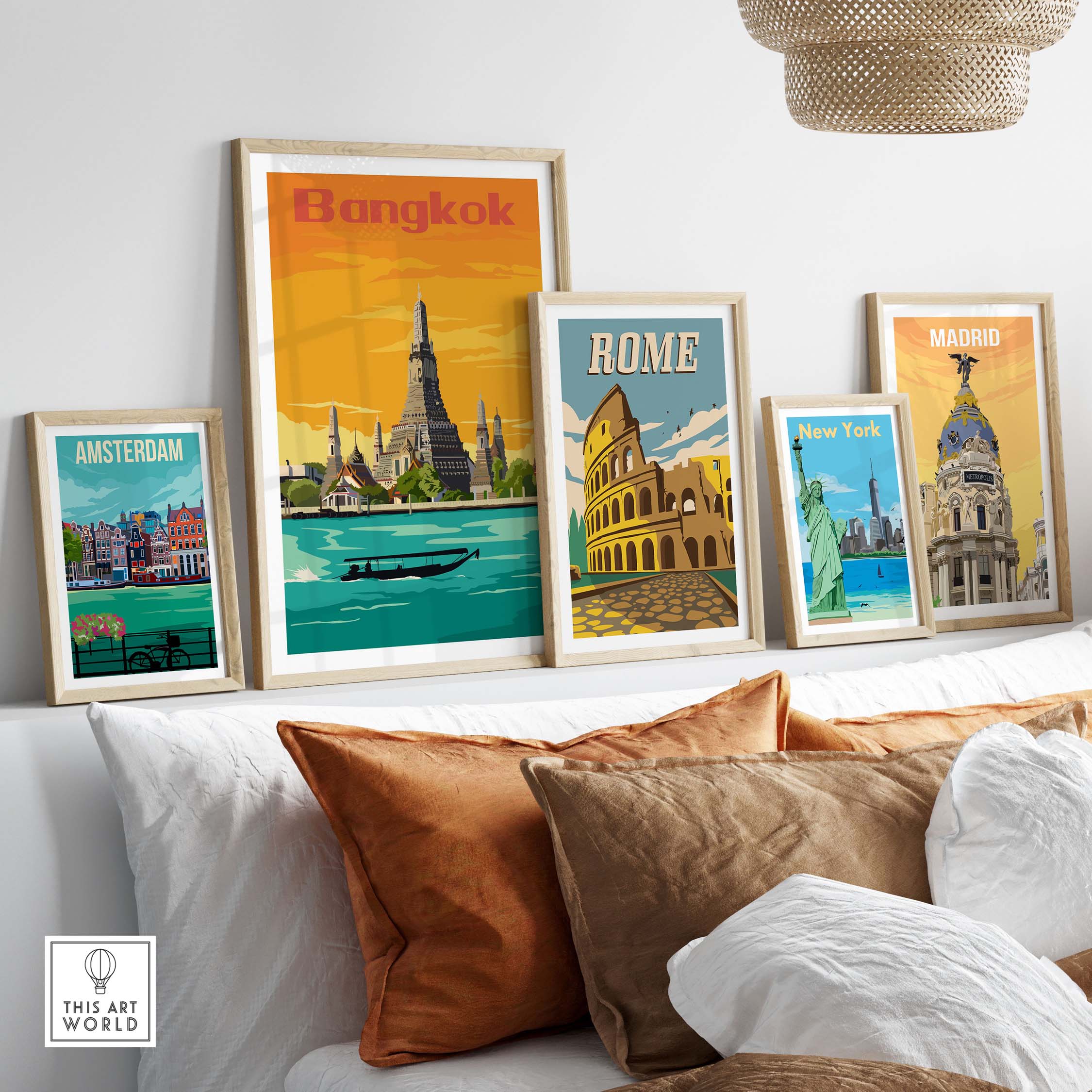 Framed vintage travel posters of Bangkok, Rome, Amsterdam, New York, and Madrid displayed on a wall above a sofa.