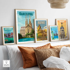 Framed vintage travel posters of Barcelona, Rome, New York, Amsterdam, and Madrid on a stylish sofa setting.