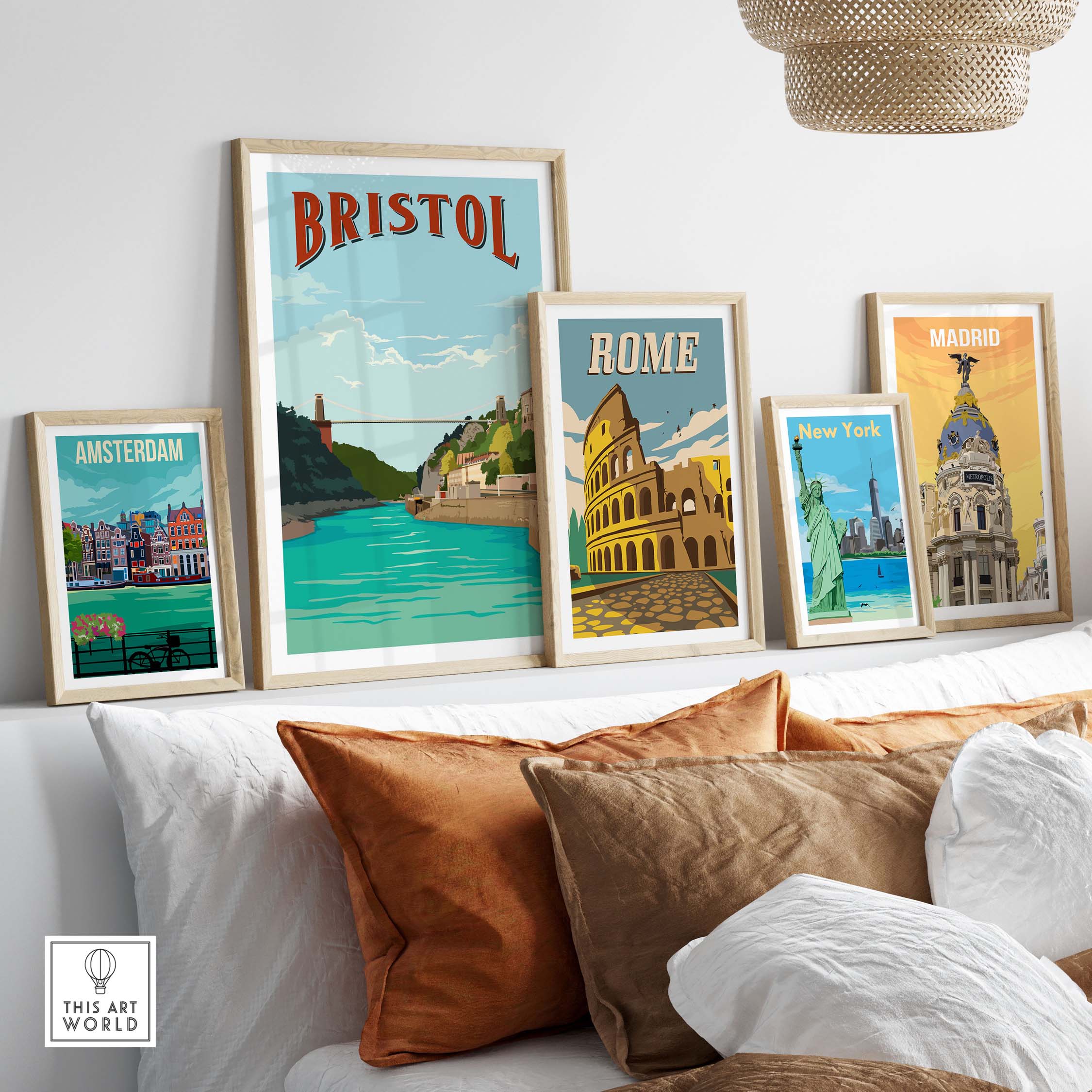 Framed vintage travel posters featuring Bristol, Rome, New York, Amsterdam, and Madrid on a stylish couch setup.