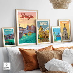 Framed Bruges, Rome, Madrid, Amsterdam, and New York vintage travel posters displayed on a stylish wall.