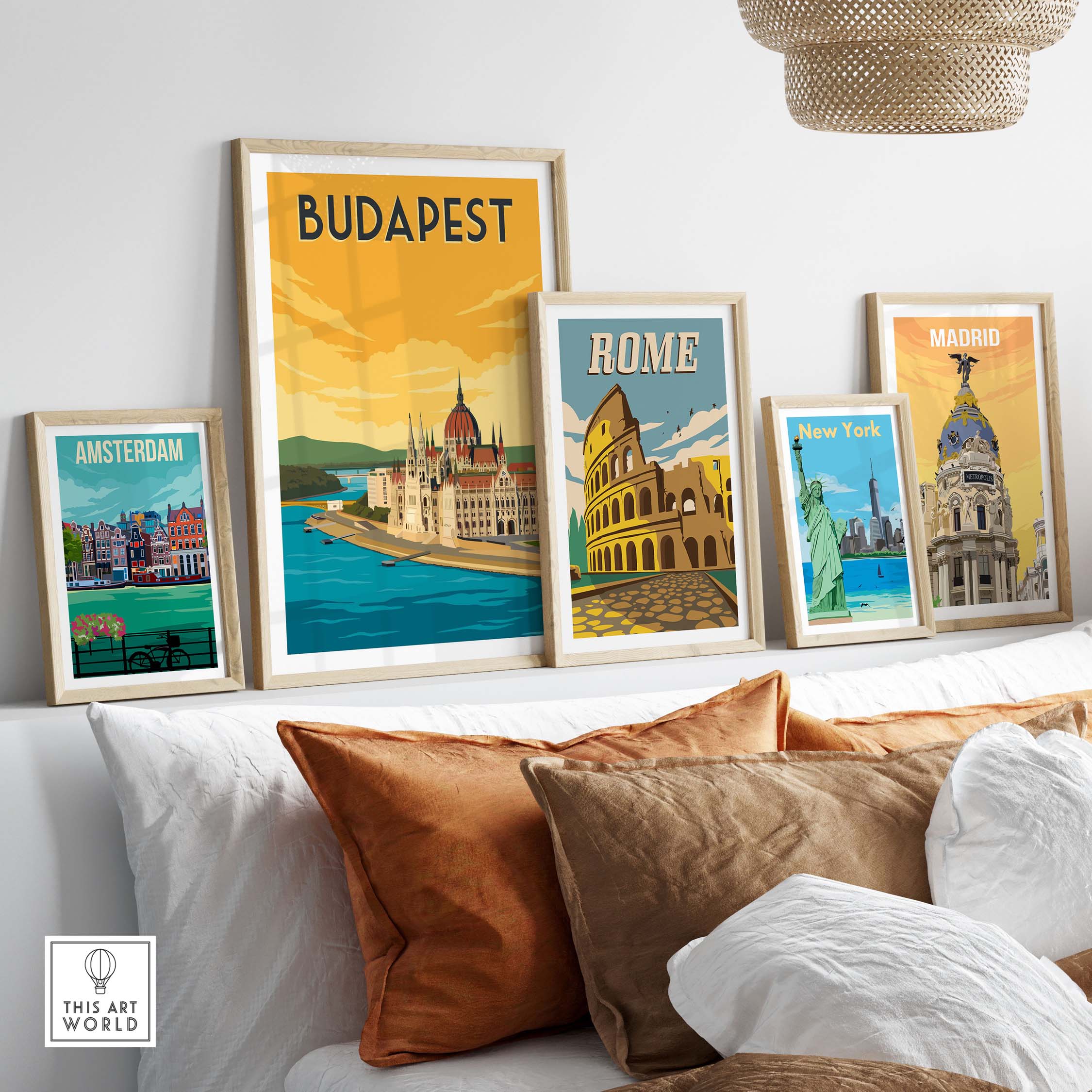 Vintage travel posters featuring Budapest, Rome, Amsterdam, New York, and Madrid arranged on a stylish sofa backdrop.