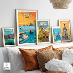 Ibiza Print Spain Sunset Poster displayed among framed vintage travel posters in a stylish living room.