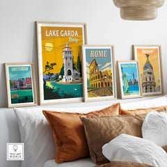 Framed Lake Garda print and vintage travel posters of Rome, Madrid, Amsterdam, and New York on a stylish wall decor.