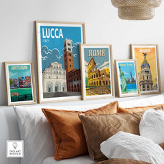 Lucca Italy wall art print displayed with other city posters on a stylish sofa in a modern living room.
