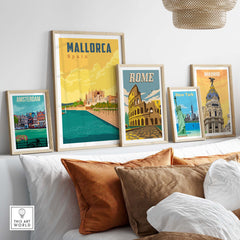 Framed vintage travel posters of Mallorca, Rome, Madrid, Amsterdam, and New York displayed on a shelf.