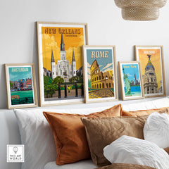 Vintage travel posters of New Orleans, Rome, Madrid, and Amsterdam displayed in stylish frames on a cozy living room couch.
