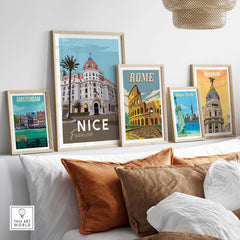 Framed travel posters including Nice France, Rome, New York, Amsterdam, and Madrid art prints displayed on a stylish sofa.