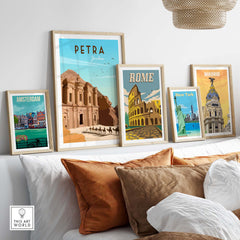 Petra travel poster print and other vintage travel art framed on a wall above a sofa in a stylish living room.