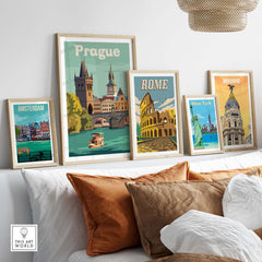 Vintage travel posters featuring Prague, Rome, Amsterdam, and New York displayed on a cozy home wall.
