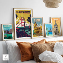 San Francisco Poster Wall Art Print alongside framed posters of Amsterdam, Rome, and New York on a stylish couch.