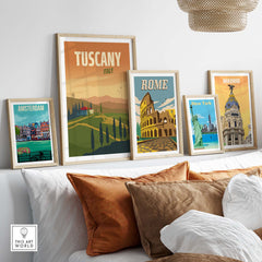 Framed Tuscany, Rome, Amsterdam, New York, and Madrid travel poster wall art prints displayed above a couch in a stylish living room.