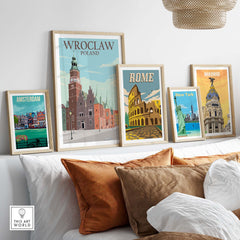 Wroclaw Poland poster among framed travel art prints of Amsterdam, Rome, New York, and Madrid on a stylish sofa.