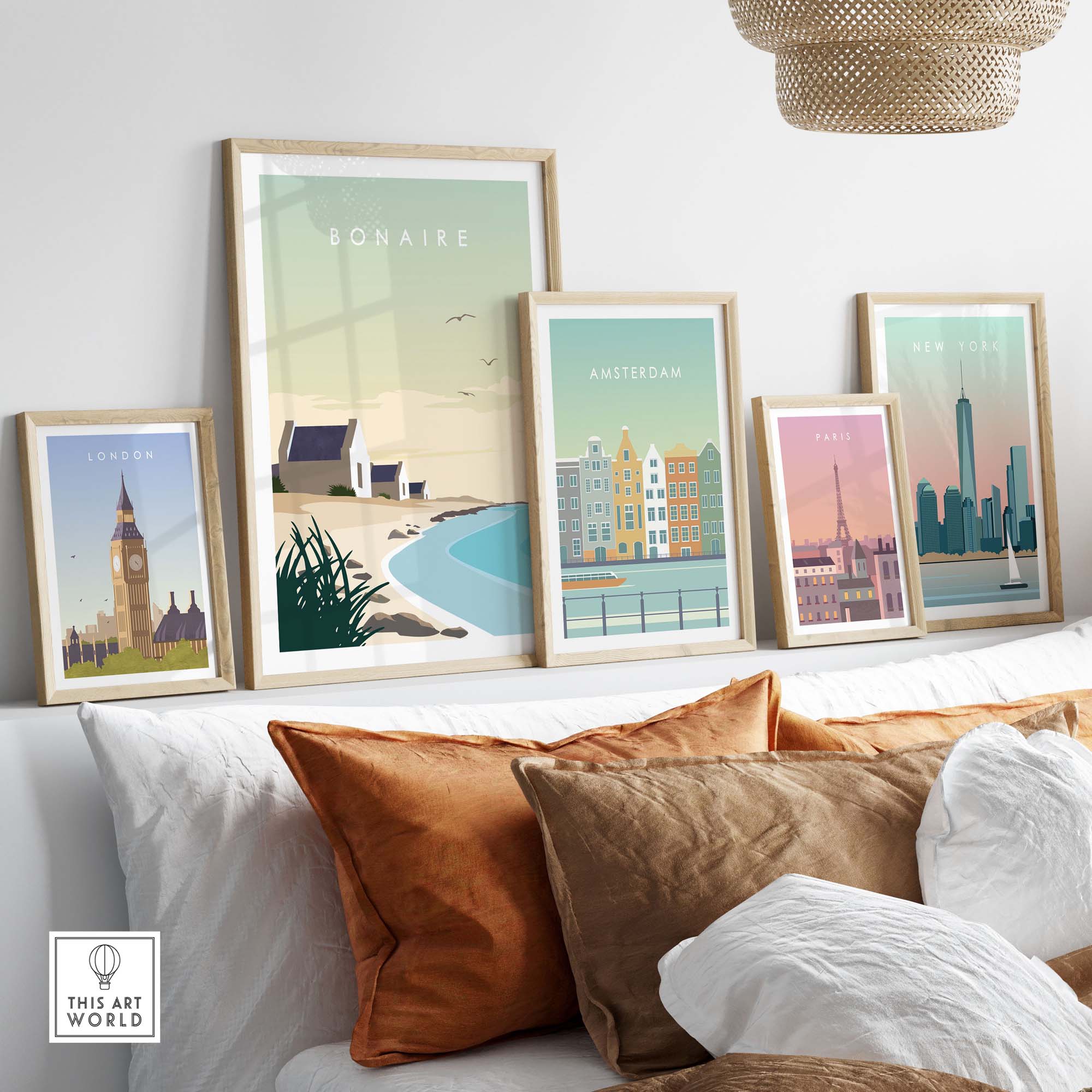 Bonaire travel poster among framed city posters, showcasing minimalist art on a stylish sofa with decorative pillows.
