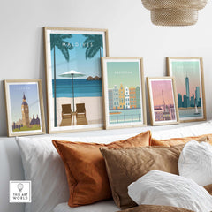 Maldives poster among travel art prints, showcasing crystal clear waters and tropical scenery in a stylish living room setting.