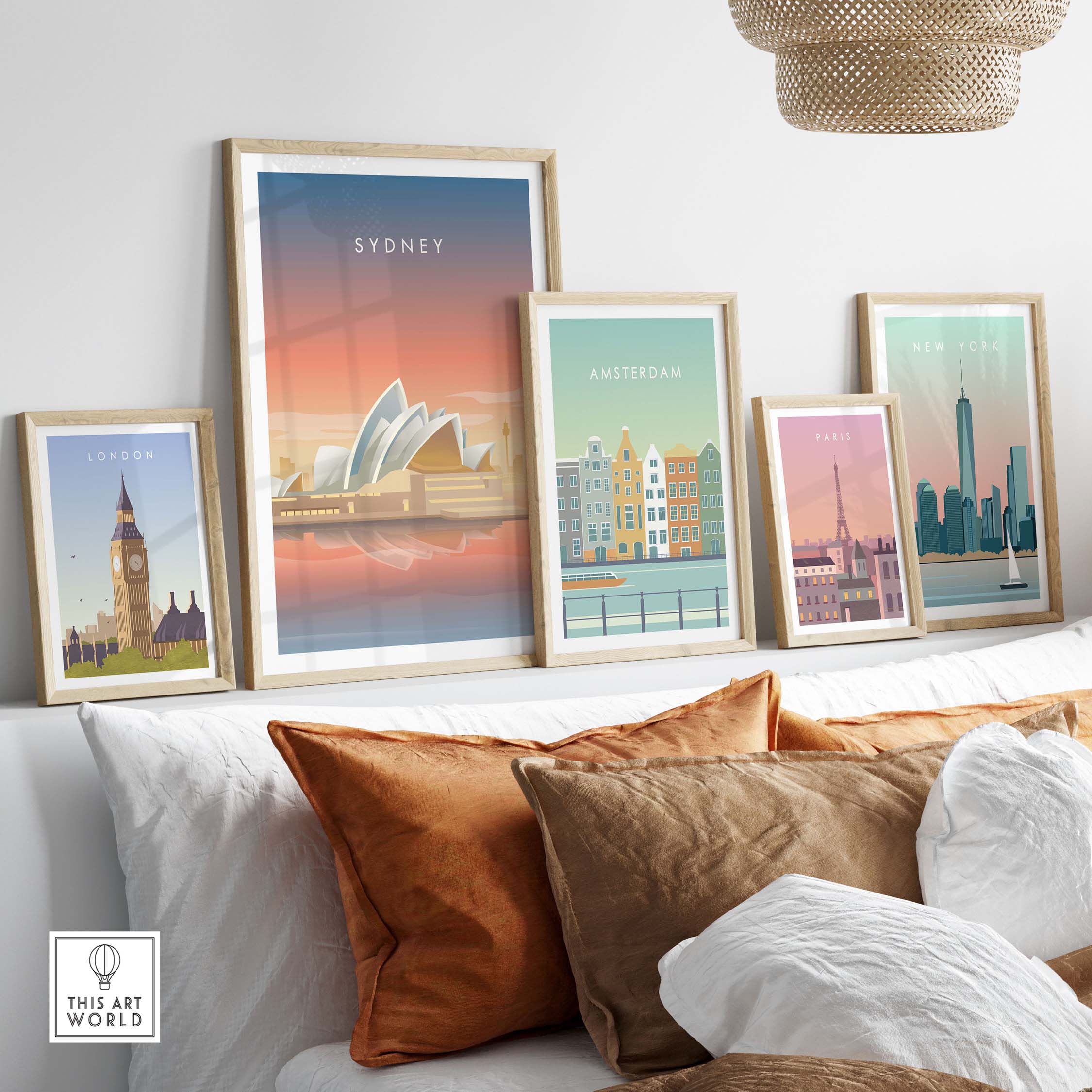 Framed Sydney wall art poster among other city posters on a cozy sofa with decorative cushions.
