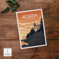 Acadia National Park wall art print featuring a lighthouse and scenic coast at sunset on a wooden surface.