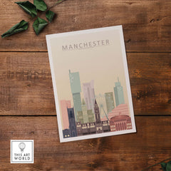 Manchester City skyline print in pastel colors showcasing iconic buildings on wooden surface.