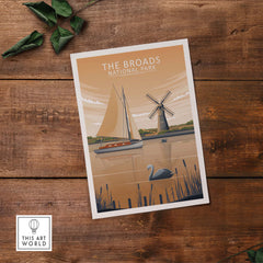 The Broads National Park poster featuring a sailboat and windmill design, presented on rustic wooden background.